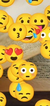 This live wallpaper showcases a playful scene with a stack yellow emoticons sitting on a table in front of an open book about love