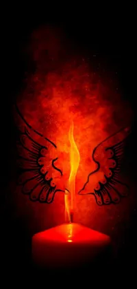This live wallpaper features an intricately designed lit candle with wings, set against a black and red background, with a hellfire backdrop, creating a dark, mystical atmosphere