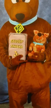 This live wallpaper features a quirky character in a whimsical costume, holding a book and teddy bear