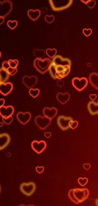 This elegant phone wallpaper features red and yellow hearts against a black background, with stunning particle lighting effects that bring the design to life