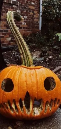 This spooky live wallpaper features a carved pumpkin with an unsettling face and sharp fangs