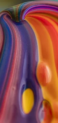 This phone live wallpaper showcases a close up of a colorful object, with vibrant and warm hues reminiscent of molten glass