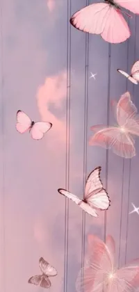 This stunning live wallpaper features a group of elegant butterflies flying in a dreamy pink pastel-hued landscape with a glowing moon and a sparkling night sky filled with stars