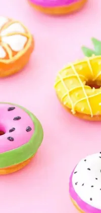 This live phone wallpaper features a collection of sugary doughnuts in a spectrum of colors and flavors