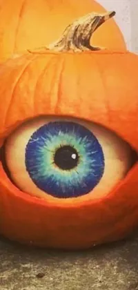 Looking for a quirky, eye-catching wallpaper for your phone? Look no further than this hyperrealistic design featuring a close-up of a pumpkin with a blue eyeball at its center