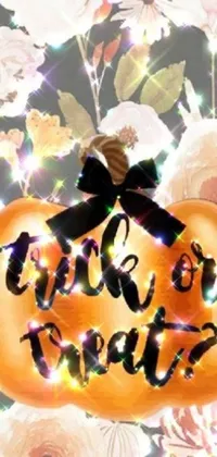 This live wallpaper features a beautiful pumpkin resting atop a bed of blooming flowers, with the phrase "trick or treat" written in a playful font
