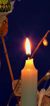 Offering a unique and captivating live wallpaper for your phone, this scene features a single lit candle perched atop a table, surrounded by a magical swarm of glowing butterflies