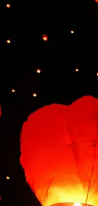 Upgrade your phone's wallpaper with this stunning live wallpaper that features a group of red lanterns floating in the air against a mesmerizing background picture