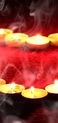 This mesmerizing live phone wallpaper features a group of lit candles arranged in the shape of a heart, casting a warming glow against a psychedelic wicca background