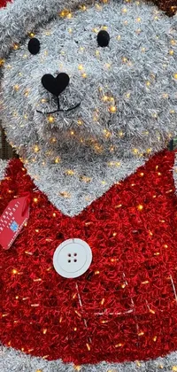 This phone live wallpaper showcases a fluffy teddy bear dressed in red and silver, made from shiny white metal