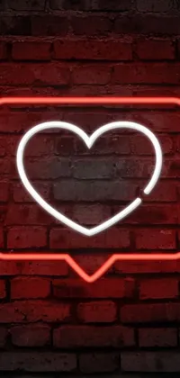 This phone live wallpaper depicts a vibrant neon heart sign on a brick wall
