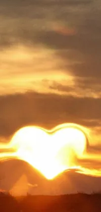 This phone live wallpaper showcases a mesmerizing sunset featuring a heart-shaped cloud and a stunning yellow and orange background