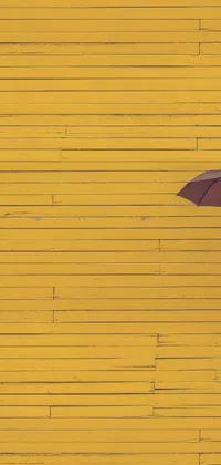 Get lost in the beauty of this stunning live wallpaper featuring a minimalist image of a woman holding an umbrella in front of a yellow wall