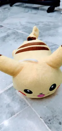 This phone live wallpaper features an adorable stuffed toy Pikachu resting on the floor