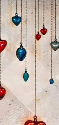 This live phone wallpaper showcases heart-shaped ornaments hanging in a kinetic art style