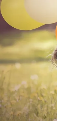 This delightful live wallpaper features a charming digital art scene of a sunny meadow, where a young girl is holding a bunch of colorful balloons