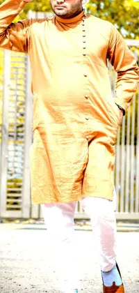 Enhance your phone's appearance with this live wallpaper of a man in a yellow shirt and white pants reminiscent of Indian culture