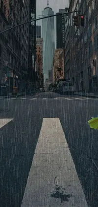 This city street phone live wallpaper presents a serene scene of a person shielding themselves from the rain under an umbrella