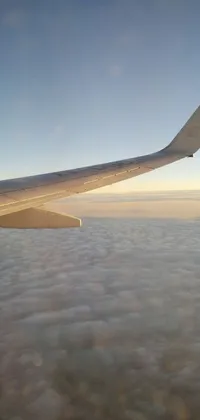 This live phone wallpaper depicts an airplane wing soaring above a scenic cloudscape