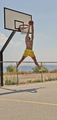 This live wallpaper showcases an athletic basketball player mid-air, wearing vibrant yellow shorts