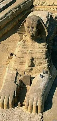 This phone live wallpaper depicts a majestic sphinx statue surrounded by intricate statues in a desert landscape