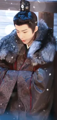 This winter-themed live wallpaper features a stunning woman sitting on a bench surrounded by snowflakes gently falling around her