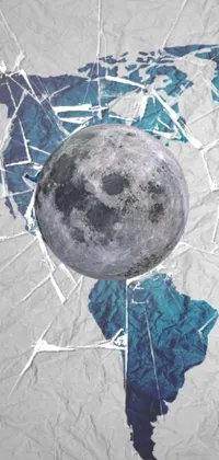 This live wallpaper for your phone features a world map on a piece of paper, a large and detailed fractured moon, and crypto-inspired elements throughout