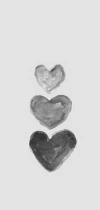 This phone live wallpaper showcases a drawing of three hearts in a vertical stack, designed in a minimalist style and featuring a water paint effect