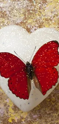 This stunning phone live wallpaper showcases a vibrant red butterfly atop a white heart against a rustic background