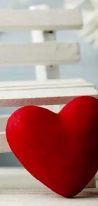 "Enjoy a stunning live wallpaper featuring a beautiful red heart resting upon a sleek white bench