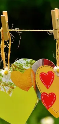 This phone live wallpaper features a charming and whimsical scene of two hearts hanging from a clothes line