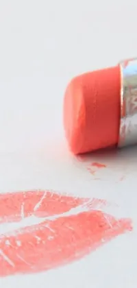 This live phone wallpaper features a close-up of a coral lipstick imprint on white paper