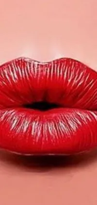 This phone live wallpaper portrays a bold and sensual image of a red lipstick up close against a soft pink backdrop