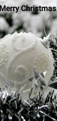 This phone live wallpaper features a close-up shot of a white Christmas ornament with a stippled design inspired by a famous artist