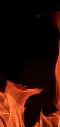 This live wallpaper for your phone features a stunning close-up of a flickering flame on a black background