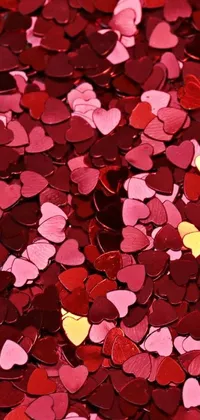 This phone live wallpaper features heart shaped red and pink confetti against a metallic, shiny background