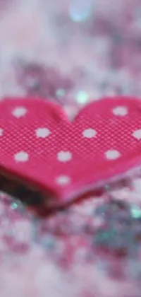This delightful phone live wallpaper features a stunning pink heart-shaped textile object with polka dots