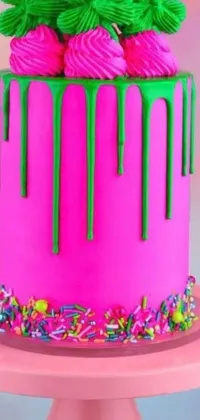 This live wallpaper showcases a cheerful pink cake with a green icing finish adorned with colorful sprinkles, set against a backdrop of neon paint drips and symbols