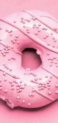 This phone live wallpaper showcases a scrumptious doughnut placed on a vibrant pink surface