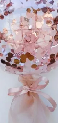 Get ready to add a touch of whimsy to your phone with this stylish live wallpaper! Featuring a charming pink balloon filled to the brim with rose gold and pink confetti dots, this design is sure to turn heads