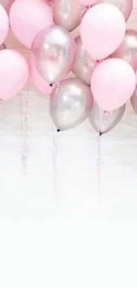 This mobile live wallpaper features an array of airy pink and silver balloons festively hanging from a ceiling, accompanied by grey and silver streamers