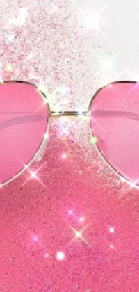 This phone live wallpaper features a trendy pair of heart-shaped sunglasses on a vibrant pink glitter background designed to add a touch of love and charm to your phone display