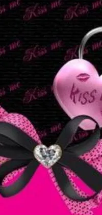 This lively phone wallpaper features a vibrant pink and black bow with a heart at the center