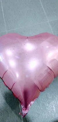 This is a lively phone live wallpaper featuring a pink heart-shaped balloon on a tiled floor
