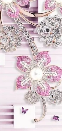 Looking for an elegant live wallpaper for your phone? Check out this stunning collection of brooches sitting on a glossy table, adorned with pink flowers and dazzling Swarovski-style crystals