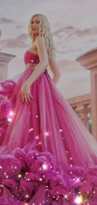 This phone live wallpaper features an image of a woman wearing a pink gown, captivatingly posing for a photograph