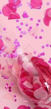 This live wallpaper features a wine glass on a table adorned with colorful confetti and surrounded by various bottles and vials
