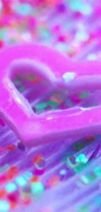 This phone wallpaper features a heart-shaped object in a close-up macro photograph with a vibrant Lisa Frank-inspired design