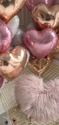 This lively phone live wallpaper features heart-shaped balloons in a rose-gold color scheme