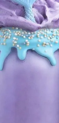 This phone live wallpaper showcases a scrumptious close-up of a cake in a jar, with layers of sugar frosting and pastel-colored cream oozing out